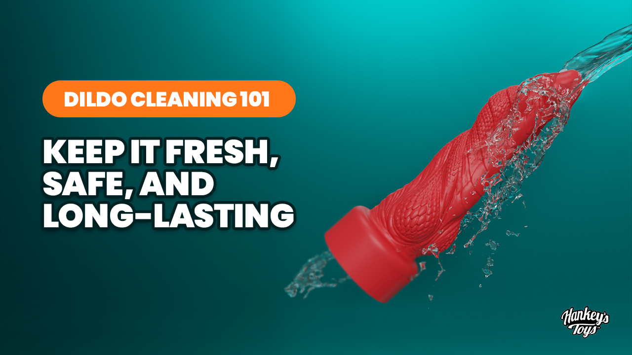 A red, textured silicone fantasy dildo the Kinky Cobra is shown being rinsed under a stream of splashing water against a teal gradient background. The image includes the text "Dildo Cleaning 101: