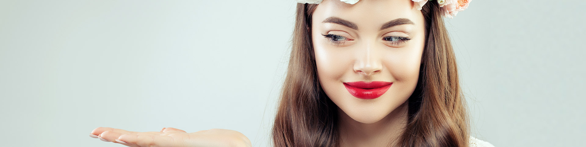 Retailers hero banner&mdash;smiling woman with red lipstick looking at her open palm, inviting shoppers to find store locations